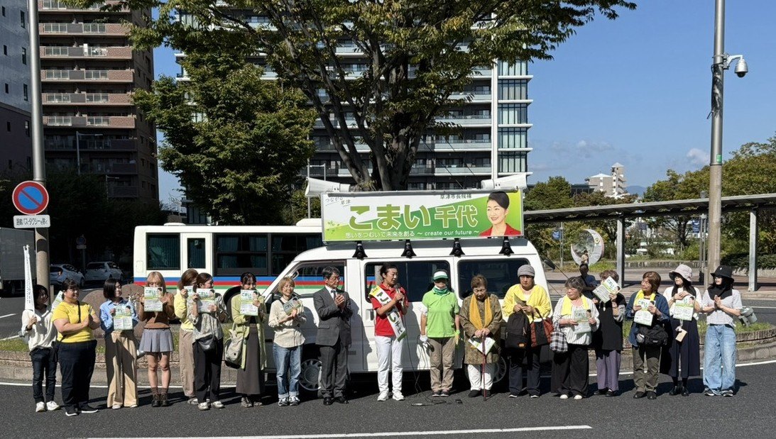 南草津駅西口ロータリーでの出発式。選挙カーの前に、善利健次選対本部長、こまい千代候補と、駆けつけた市民の皆さんが並んでいる。