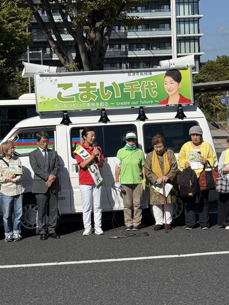 選挙カーの前で街頭演説をするこまい千代候補と、見守る支援者の皆さん。