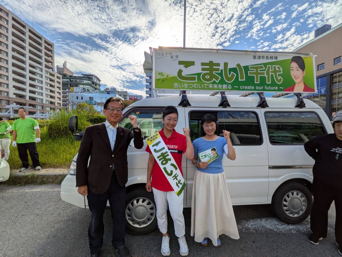 出発式にて、選挙カーの前でガッツポーズをするこまい千代候補と支援者の皆さん。