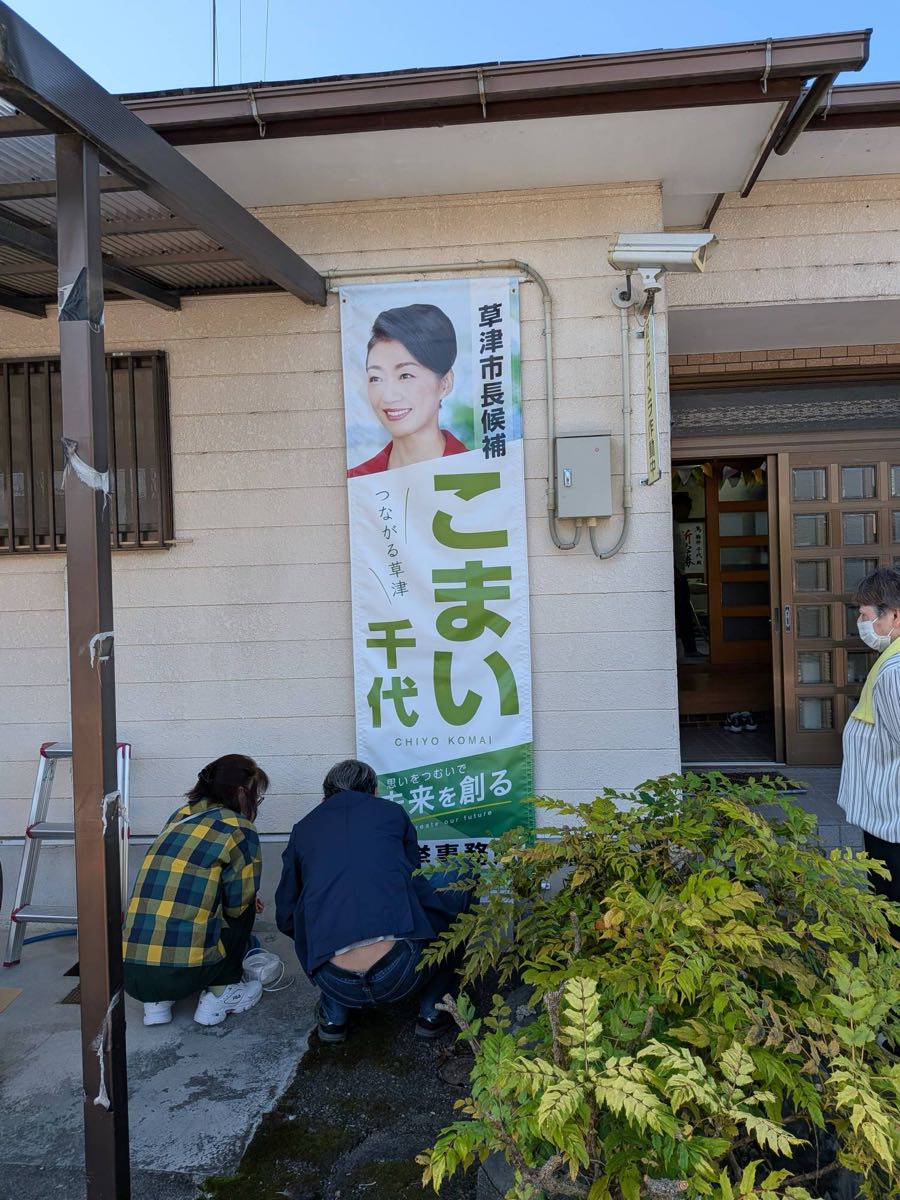 選挙事務所前に掲げられたこまい千代候補の看板を取り付ける支援者の皆さん。